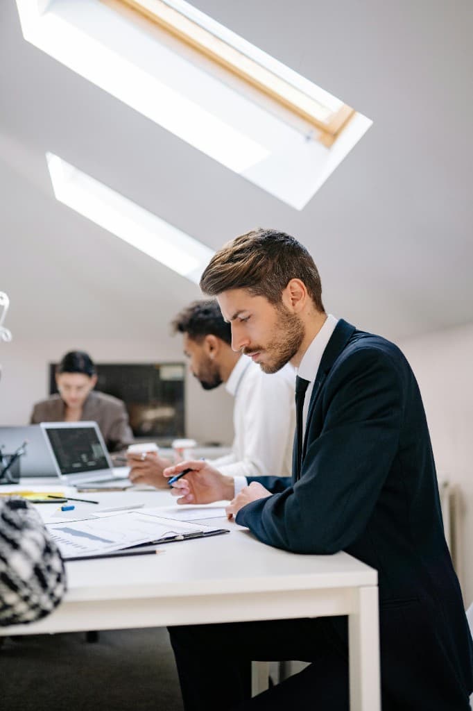 Professionals reviewing charts and documents at a desk in a bright office